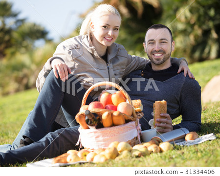 Couple lounging at picnic outdoors Couple lounging at picnic outdoors 31334406