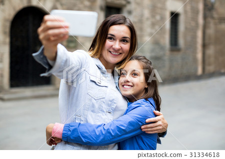 Mother and daughter making selfie 31334618