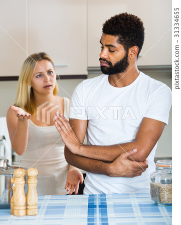 interracial family couple with serious faces quarrelling in kitchen interracial family couple with serious faces quarrelling in kitchen 31334655