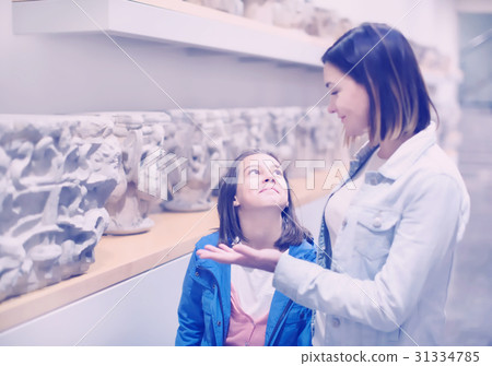 Mother and daughter exploring bas-reliefs in museum 31334785