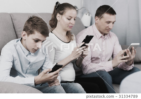 Parents and son using phones 31334789