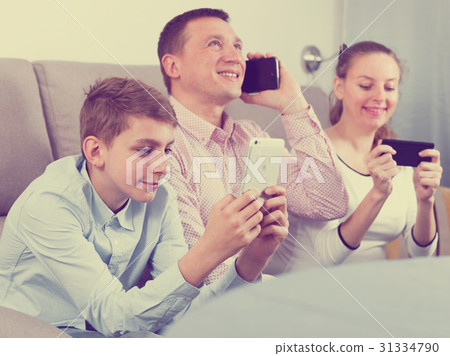 Parents and son using phones 31334790