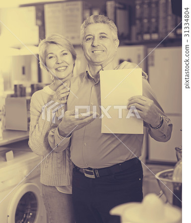 Charming mature couple buying on credit agreement for home appliances 31334804