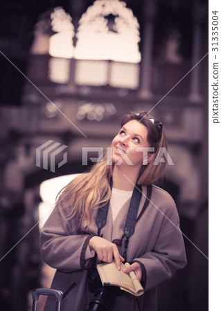 Blond smiling girl holding brochure Blond smiling girl holding brochure 31335004