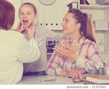 Little girl talking with doctor about sick of throat 31335005
