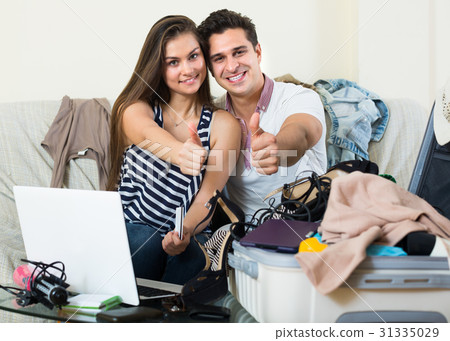 adults sitting near laptop and luggage adults sitting near laptop and luggage 31335029