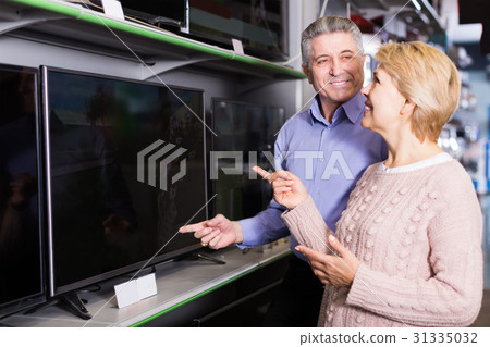 Nice mature married couple are choosing home modern TV Nice mature married couple are choosing home modern TV 31335032