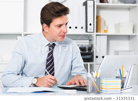 Businessman in office clothes filling up documents Businessman in office clothes filling up documents 31335331