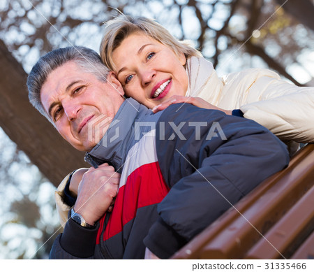 cheerful mature married couple holding hands each other in park 31335466