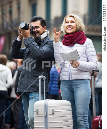 tourists with map and luggage on city street 31335533
