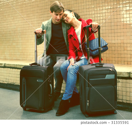 Young passengers with luggage waiting for train at subway station Young passengers with luggage waiting for train at subway station 31335591