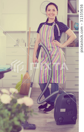 Cheerful girl vacuum cleaning floor Cheerful girl vacuum cleaning floor 31335656