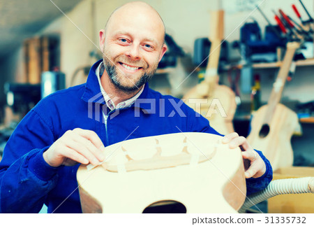 Guitar-maker at workshop. Guitar-maker at workshop. 31335732