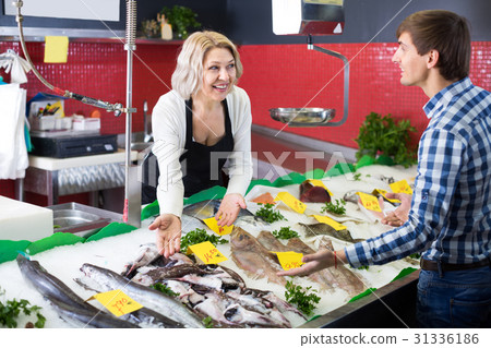 Mature woman selling fish to male Mature woman selling fish to male 31336186