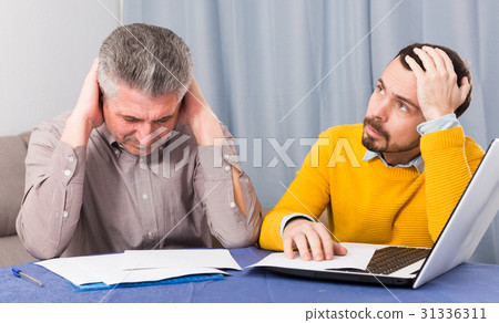 Adult father and son discuss contract Adult father and son discuss contract 31336311