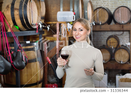 Portrait of female holding wine glass in winery Portrait of female holding wine glass in winery 31336344