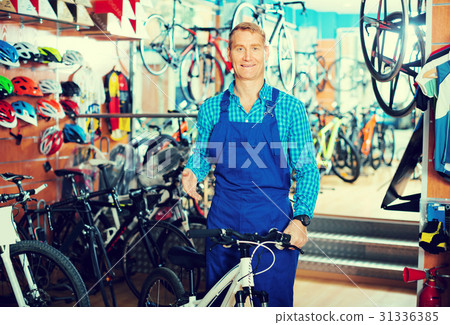 man in uniform working in bicycle shop . 31336385