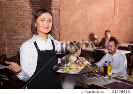 Young woman waiter demonstrating restaurant to visitors 31336416