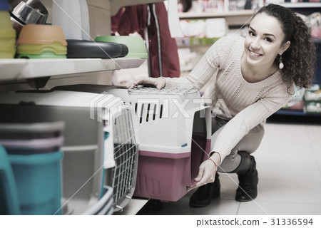 Girl buying kennel for pet in shop. 31336594
