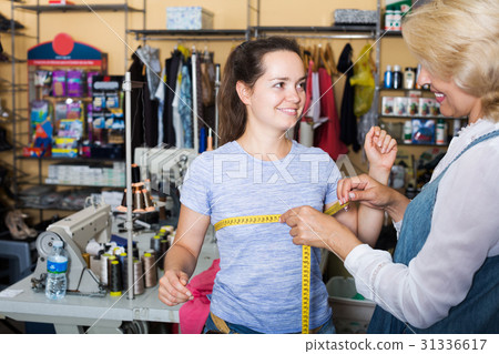 Tailor measuring customer in atelier 31336617