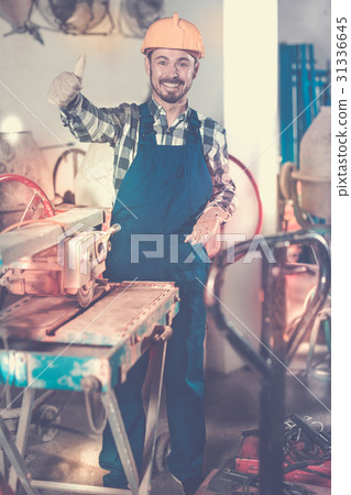 Working man practicing with disk saw machine 31336645