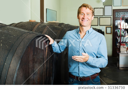 man in cellar with wine woods . 31336730