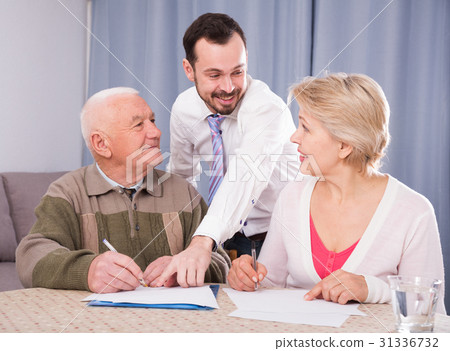 Woman and eldery man signing agreement 31336732
