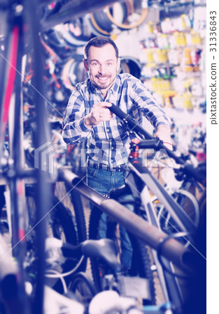 Man considers bicycle handlebar in store Man considers bicycle handlebar in store 31336843