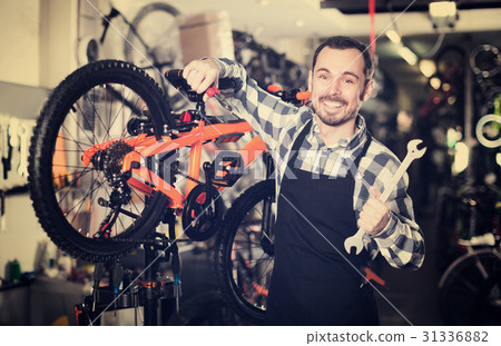 Racer is working on master bicycle assembly Racer is working on master bicycle assembly 31336882