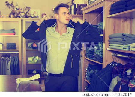 Man choosing new suit in male clothing store 31337014