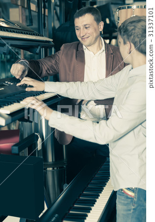 Man with son select a synthesizer 31337101