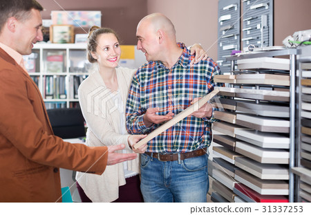 Ordinary young customers choosing kitchen facade Ordinary young customers choosing kitchen facade 31337253