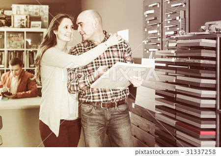 happy family couple looking at kitchen facade in furniture works happy family couple looking at kitchen facade in furniture works 31337258