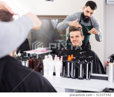 guy stylist creating haircut for man client at hairdressing salon 31337342