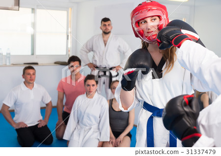 Instructor and trainee are sparring in pair to use taekwondo technique 31337479