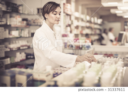 Adult female arranging assortment of products Adult female arranging assortment of products 31337611