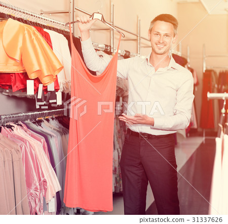 Portrait of young man offering to girlfriend dress variants 31337626