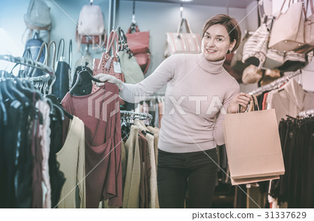 Cheerful female deciding on pretty blouse 31337629