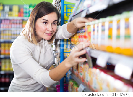 Smiling female shopper searching for baby food 31337674