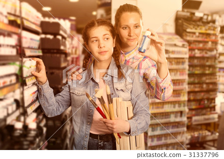 Mother and daughter holding jar with color paint Mother and daughter holding jar with color paint 31337796