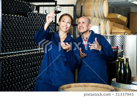 Two winery workers holding glass of wine 31337943