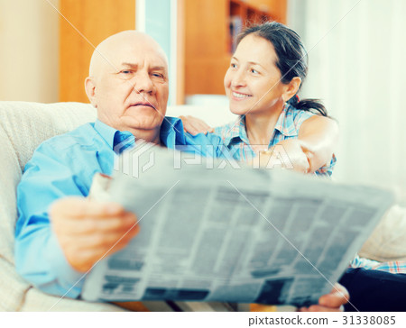 Happy couple of grandparents with newspaper 31338085