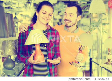 man and a girl are examining the options for lamps man and a girl are examining the options for lamps 31338244