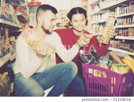 Family buying vegetable oil at grocery shop 31338616