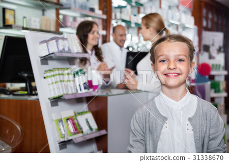 Little glad girl in the pharmacy with parents and pharmacist Little glad girl in the pharmacy with parents and pharmacist 31338670