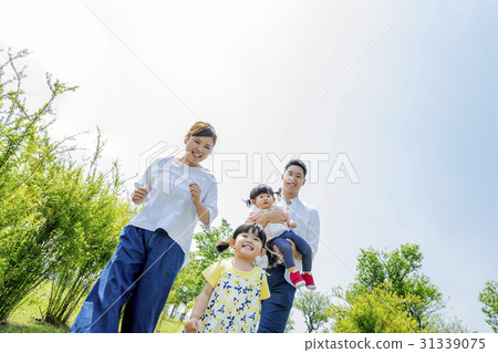 Four people walking in a fresh green park 31339075