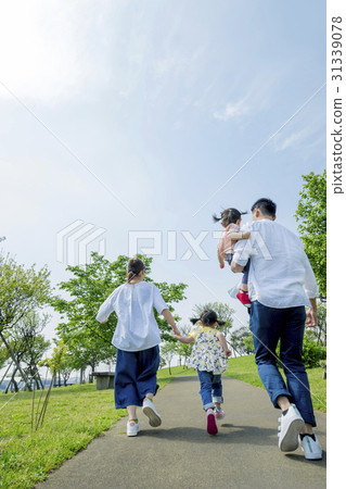 The back of the four people walking in the fresh green park 31339078