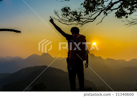 Hiking man stand relax on hill enjoying sunset Hiking man stand relax on hill enjoying sunset 31340600