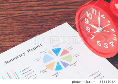 red clock on chart on wooden background.  31341042