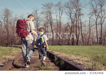 Father and son walking on the railway at the day time. Father and son walking on the railway at the day time. 31342408